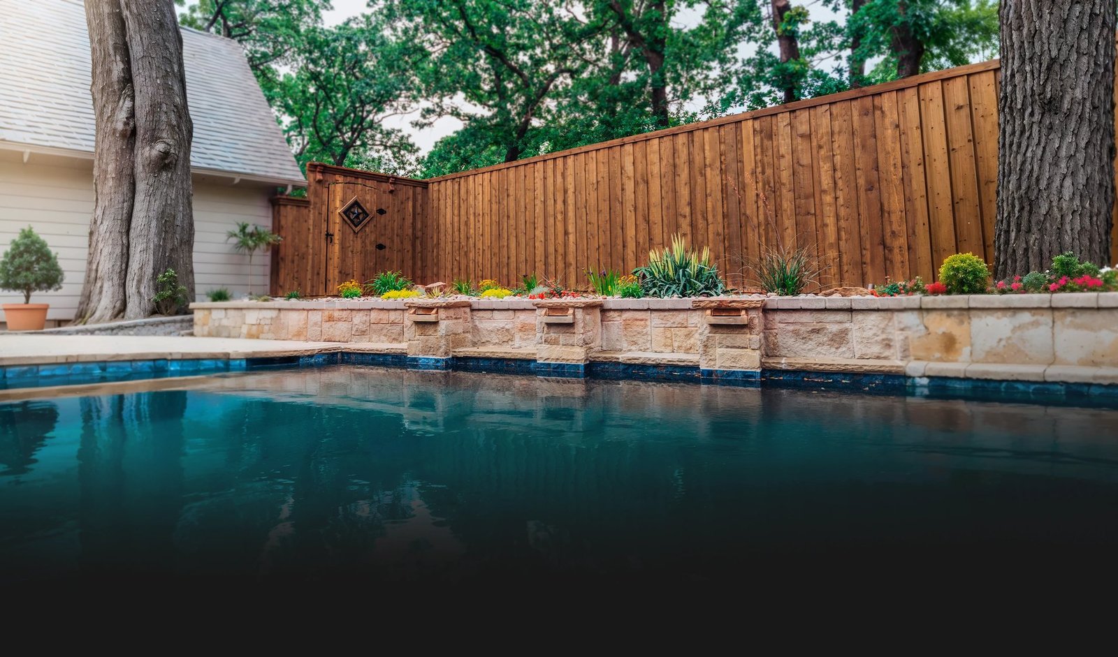Outdoor living space with pool, pergola and cedar fence by Estrada
