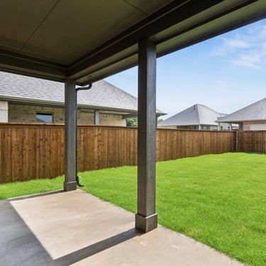 Covered patio with cedar privacy fence and green lawn