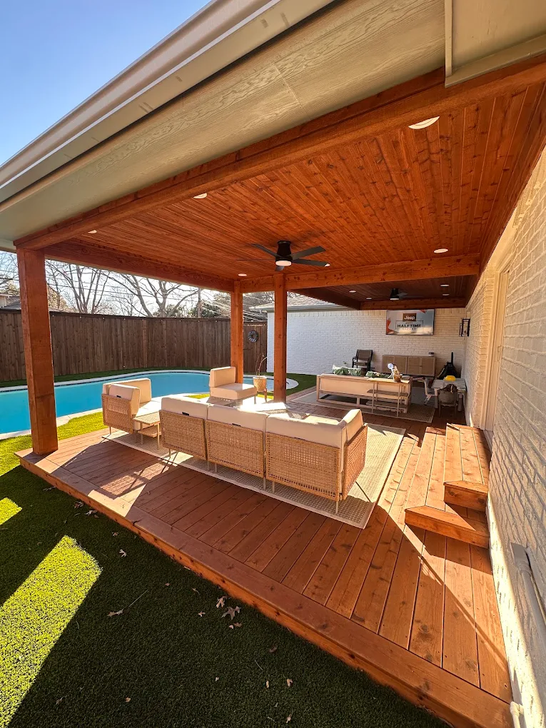 Attached patio cover with a cedar tongue-and-groove ceiling, ceiling fans and recessed lights over a wood deck beside a pool